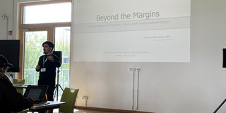 The image shows the team member, Víctor Cobs-Muñoz, delivering his keynote talk.