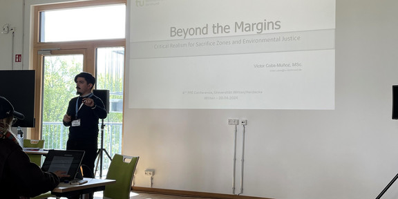 The image shows the team member, Víctor Cobs-Muñoz, delivering his keynote talk.