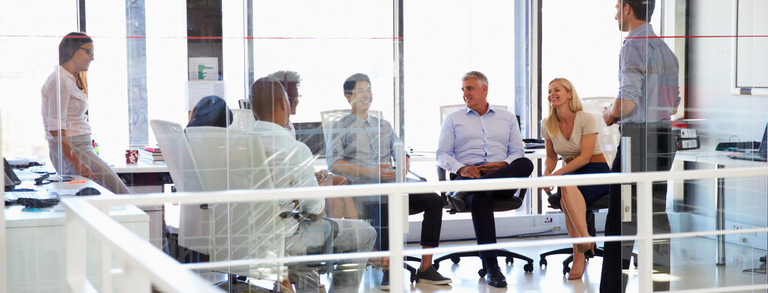 six people sitting together in a bright room are facing each other